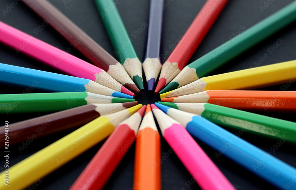 colorful bright pencils lie all around on a black background colorful bright pencils lie all around on a black background
