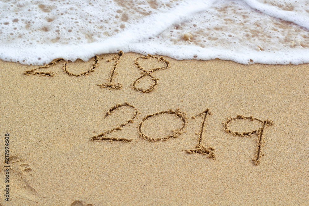 New Year 2019 sign in tropical beach sand with turquoise ocean New Year 2019 sign in tropical beach sand with turquoise ocean