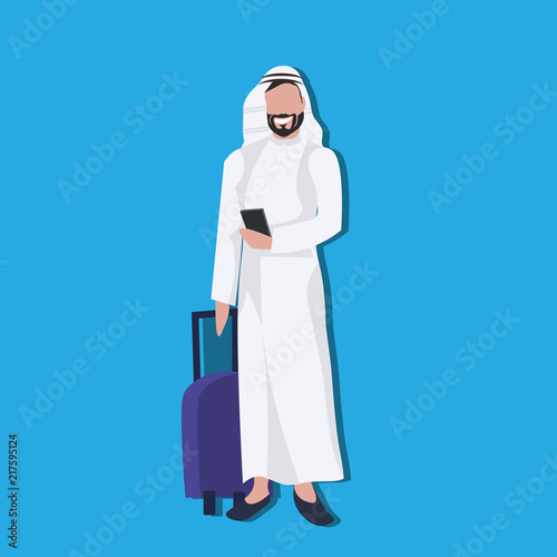 Arabic businessman using smartphone holding valise wearing traditional clothes travel concept male cartoon character avatar blue background full length flat vector illustration