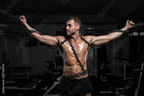 Muscular man slave in chains in gym  the prisoner