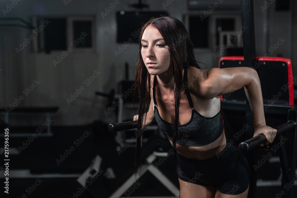 Fitness woman doing push-ups on uneven bars in crossfit gym. Fitness woman doing push-ups on uneven bars in crossfit gym.