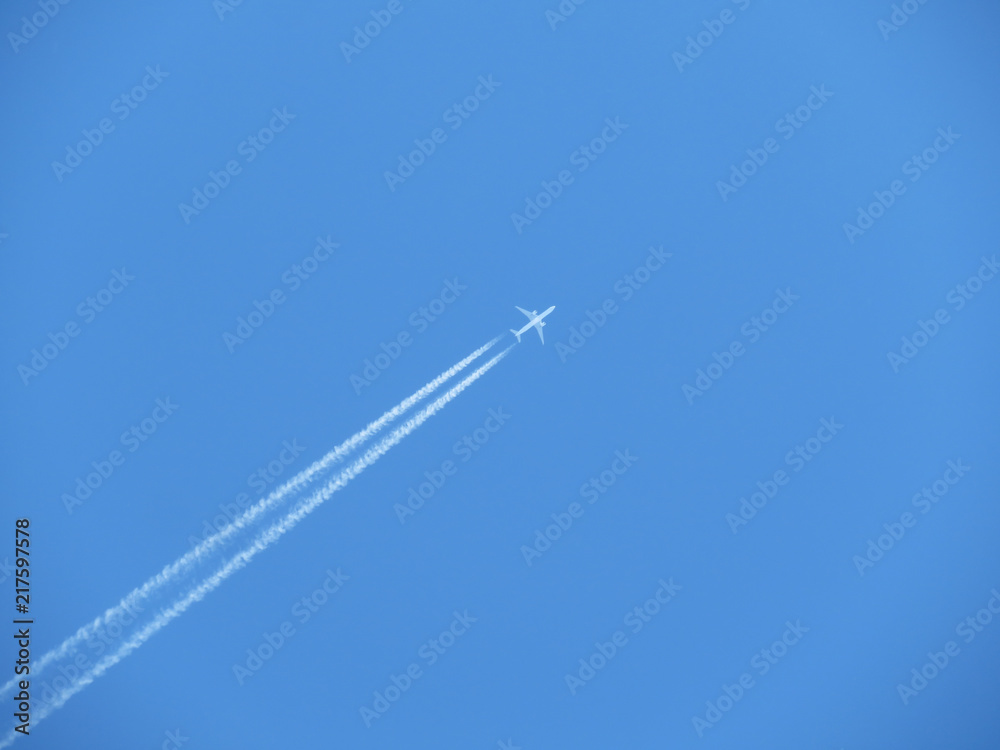Trail of jet plane on clear blue sky. Airplane in the sky with contrail Trail of jet plane on clear blue sky. Airplane in the sky with contrail