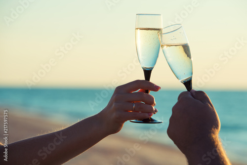 A loving couple drinks champagne on the seashore. Romantic. photo