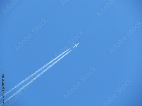 Trail of jet plane on clear blue sky. Airplane in the sky with contrail 