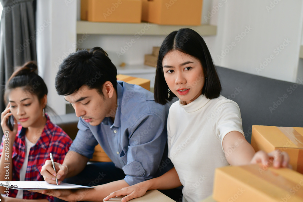 Sme business concept. Young Asian people are packing their packages.Delivery business Small and Medium Enterprise (SMEs). Young man is working in the house.Young Owner Start up for Business Online. Sme business concept. Young Asian people are packing their packages.Delivery business Small and Medium Enterprise (SMEs). Young man is working in the house.Young Owner Start up for Business Online.