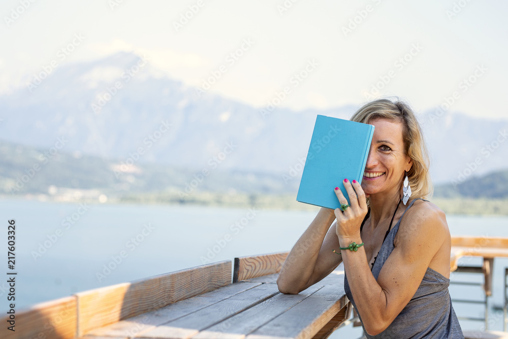 Portrait of a pretty young girl hiding behind an open book Portrait of a pretty young girl hiding behind an open book