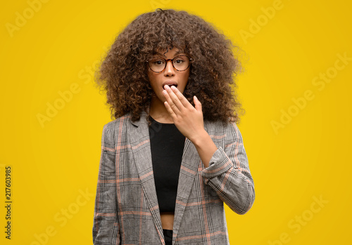 African american woman wearing a jacket cover mouth with hand shocked with shame for mistake, expression of fear, scared in silence, secret concept