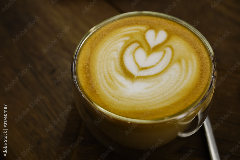 Tulip pattern latte art over freshly brew espresso coffee in a glass. Good for caffeine boost in the morning. Selective focus. Close up.