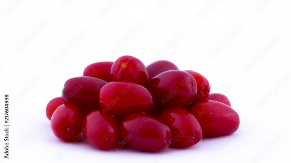 Closeup shooting of a pile of cornelian cherry dogwood fruits rotating on the turntable isolated on the white background. Side view. Macro. Closeup shooting of a pile of cornelian cherry dogwood fruits rotating on the turntable isolated on the white background. Side view. Macro.