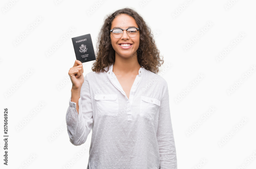 Young hispanic woman holding passport of United States of America with a happy face standing and smiling with a confident smile showing teeth Young hispanic woman holding passport of United States of America with a happy face standing and smiling with a confident smile showing teeth
