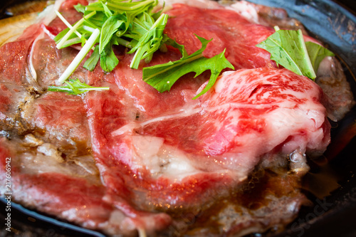 Tasty and delicious Japanese Sukiyaki nabe with best-quality cuts of thinly sliced sirloin or rib eye or tenderloin Kuroge Wagyu beef in a cast iron pan. Good Marble Score. Natural light. Close up.