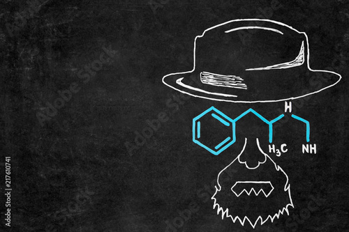 Drawn chalk man with hat and glasses as chemical formula on blackboard with copy space.