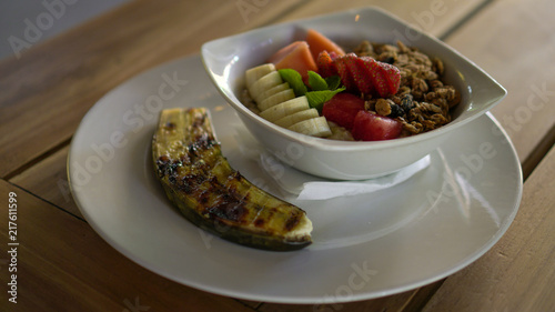 Breakfast oatmeal with fruits, nuts and fried banana