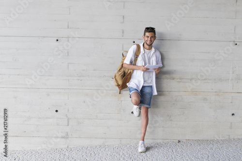 student with books in gray wall background