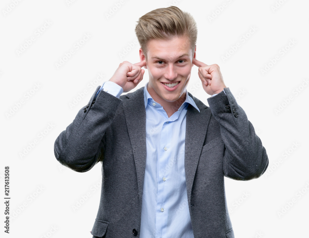 Young handsome blond business man covering ears with fingers with annoyed expression for the noise of loud music. Deaf concept. Young handsome blond business man covering ears with fingers with annoyed expression for the noise of loud music. Deaf concept.