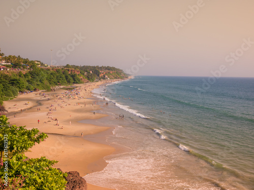 Konstfotografi Beautiful and relaxing beach flanked by green palm trees at sunset