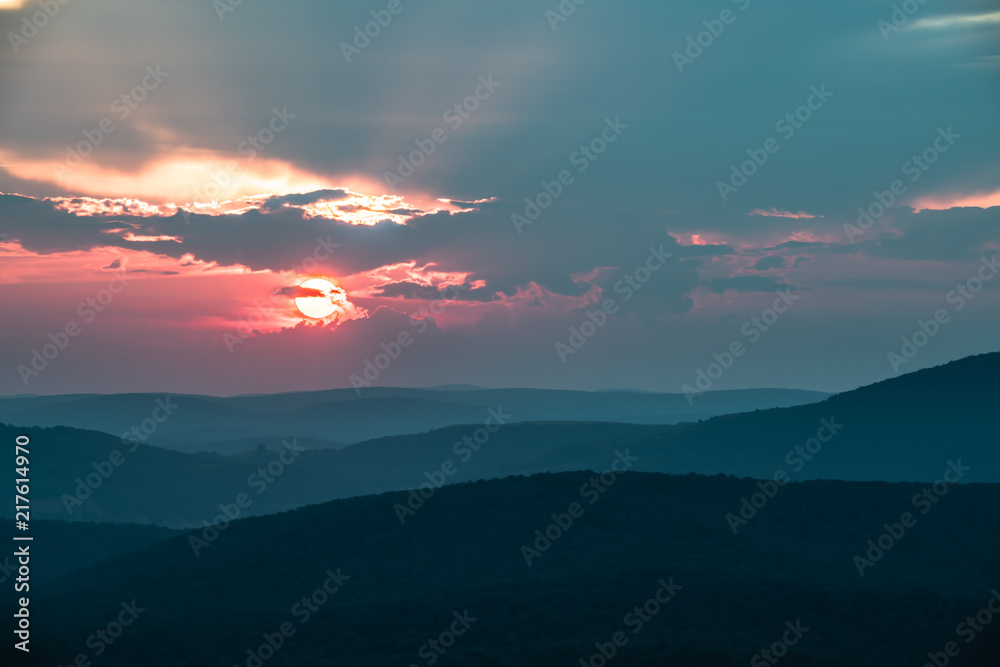 The sun sets behind a giant thunderstorm cloud in the Appalachian Mountains seen from Spruce Knob in West Virginia