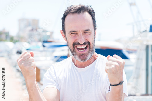 Handsome middle age man in marina screaming proud and celebrating victory and success very excited, cheering emotion