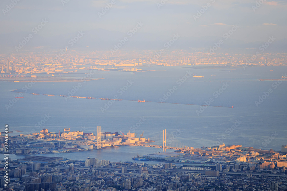 Fototapeta premium Światło słoneczne pada na wiszący most i oświetla zachodnią Osakę