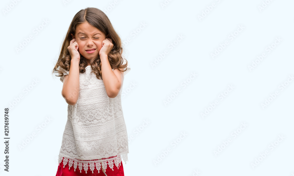 Brunette hispanic girl covering ears with fingers with annoyed expression for the noise of loud music. Deaf concept. Brunette hispanic girl covering ears with fingers with annoyed expression for the noise of loud music. Deaf concept.