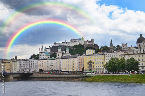 SALZBURG, AUSTRIA - JUNE 22, 2018: Picturesque view of city street on riverside and rainbow in sky