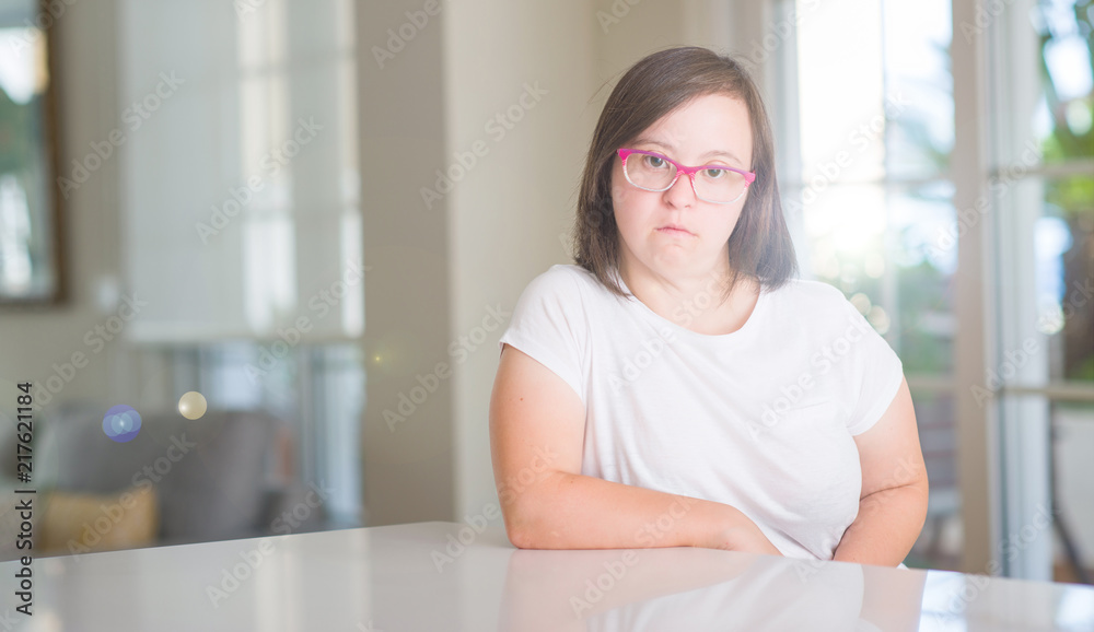 Down syndrome woman at home with a confident expression on smart face thinking serious