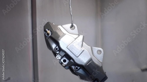 The painter paints the details of the car's brake system