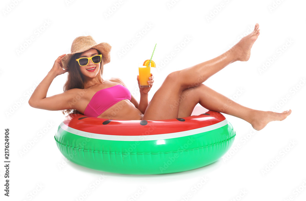 Naklejka premium Beautiful young woman with inflatable ring and glass of cocktail on white background