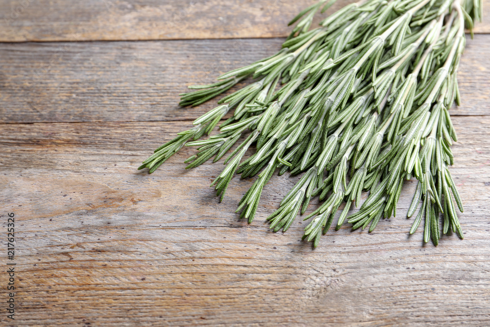 Fresh rosemary twigs on wooden table Fresh rosemary twigs on wooden table