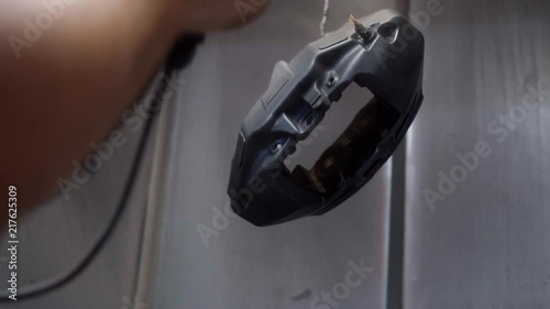 The painter paints the details of the car's brake system