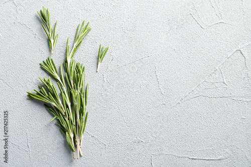 Fresh rosemary twigs on gray table, top view