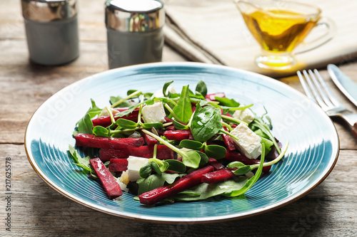 Plate with delicious beet salad served on table
