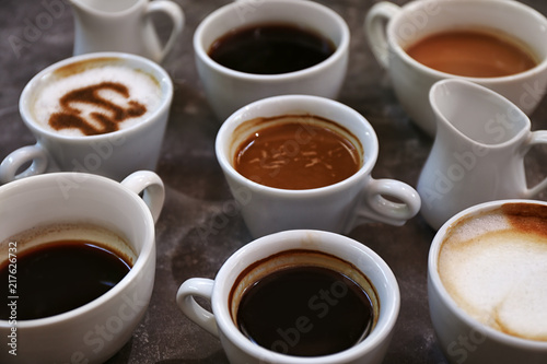 Cups of fresh aromatic coffee on grey background