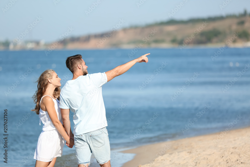 Happy young couple at beach on sunny day Happy young couple at beach on sunny day