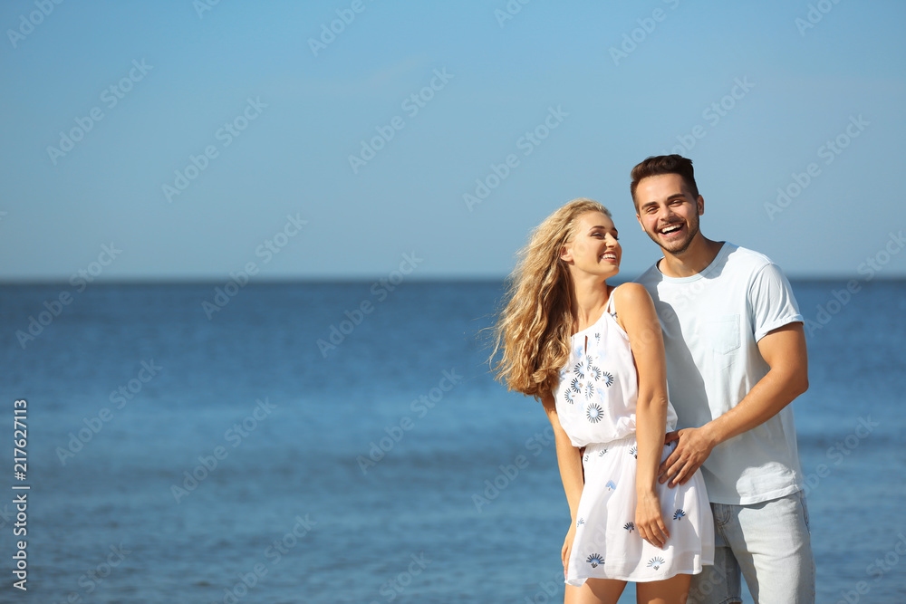 Happy young couple at beach on sunny day Happy young couple at beach on sunny day