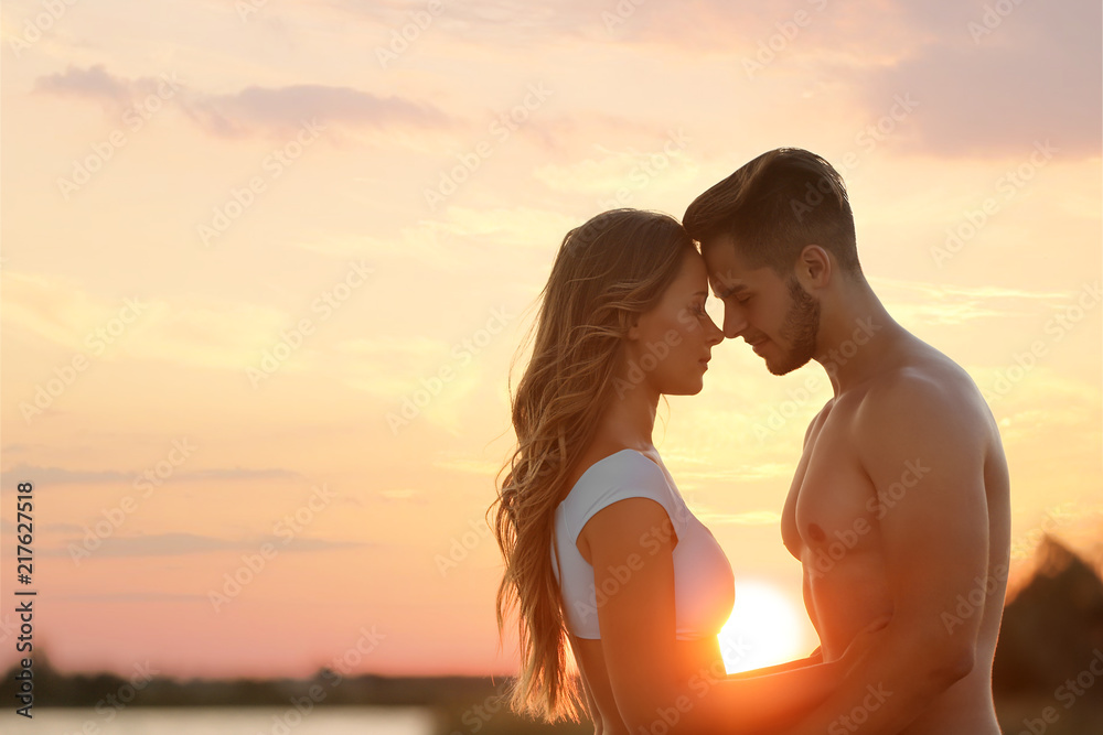 Obraz premium Happy young couple in beachwear outdoors at sunset