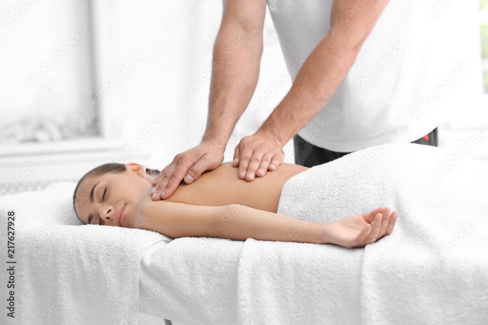Relaxed woman receiving back massage in wellness center Relaxed woman receiving back massage in wellness center