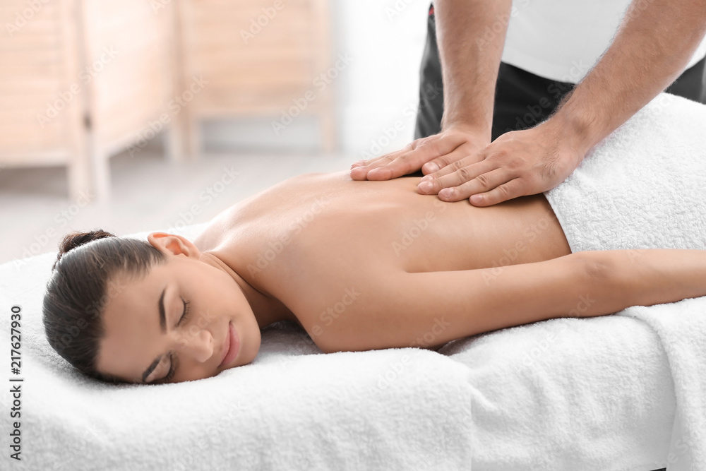 Relaxed woman receiving back massage in wellness center Relaxed woman receiving back massage in wellness center
