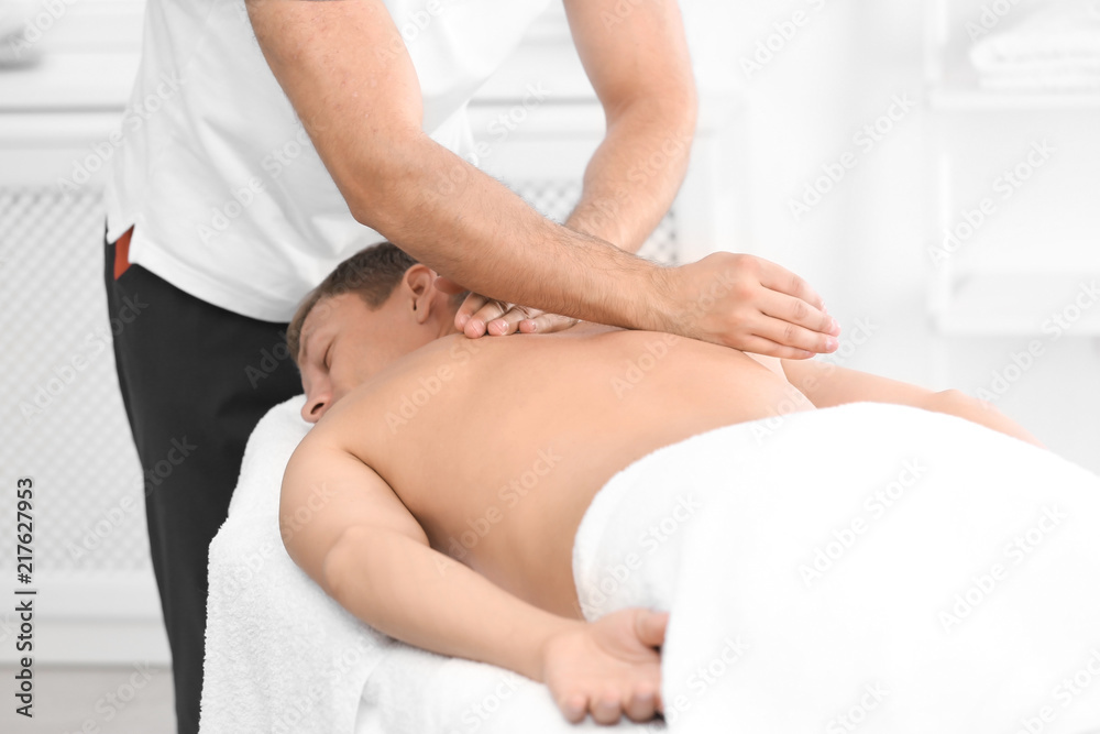 Relaxed man receiving back massage in wellness center Relaxed man receiving back massage in wellness center