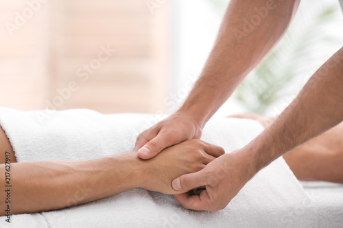 Young man receiving massage in salon, closeup