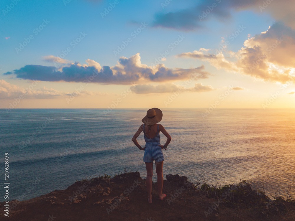 Silhouette of a girl in sunset / sunrise time over the ocean.