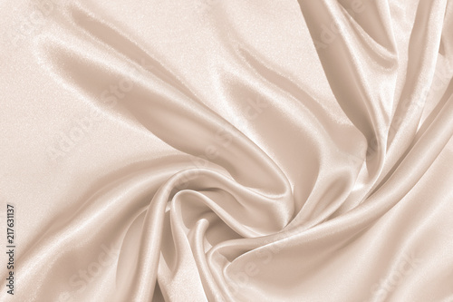 The texture of the satin fabric of beige color for the background 