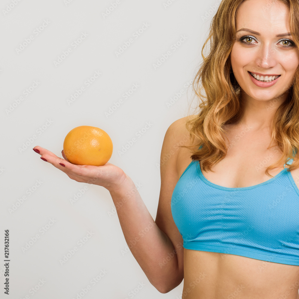 Young energetic happy sporty woman holding orange Young energetic happy sporty woman holding orange