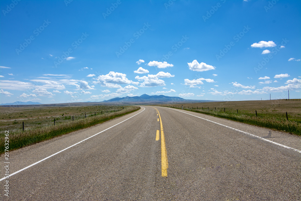 Highway with Sweetgrass Hills near Writing On Stone Provincial Park Highway with Sweetgrass Hills near Writing On Stone Provincial Park
