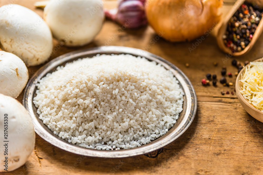 Ingredients for risotto with mushrooms on a rustic wooden table Ingredients for risotto with mushrooms on a rustic wooden table