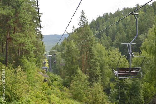 The cable car (funicular) passes in the mountains above the forest. Altai. Russia