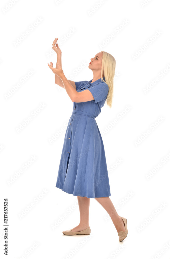 full length portrait of blonde girl wearing blue dress, standing pose. isolated on white  studio background.