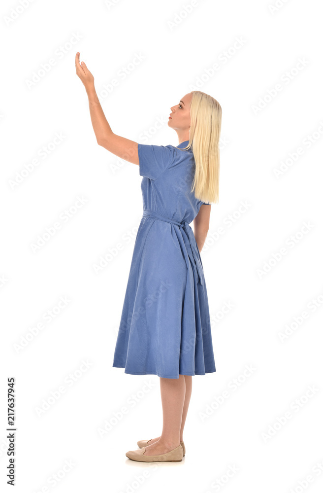 full length portrait of blonde girl wearing blue dress, standing pose. isolated on white studio background. full length portrait of blonde girl wearing blue dress, standing pose. isolated on white studio background.