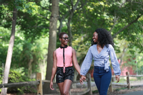 Happy black women holding hands while walking