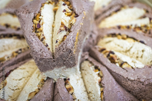 Eastern sweetness dessert halva with hazelnuts and chocolate close-up, soft selective focus with shallow depth of field photo